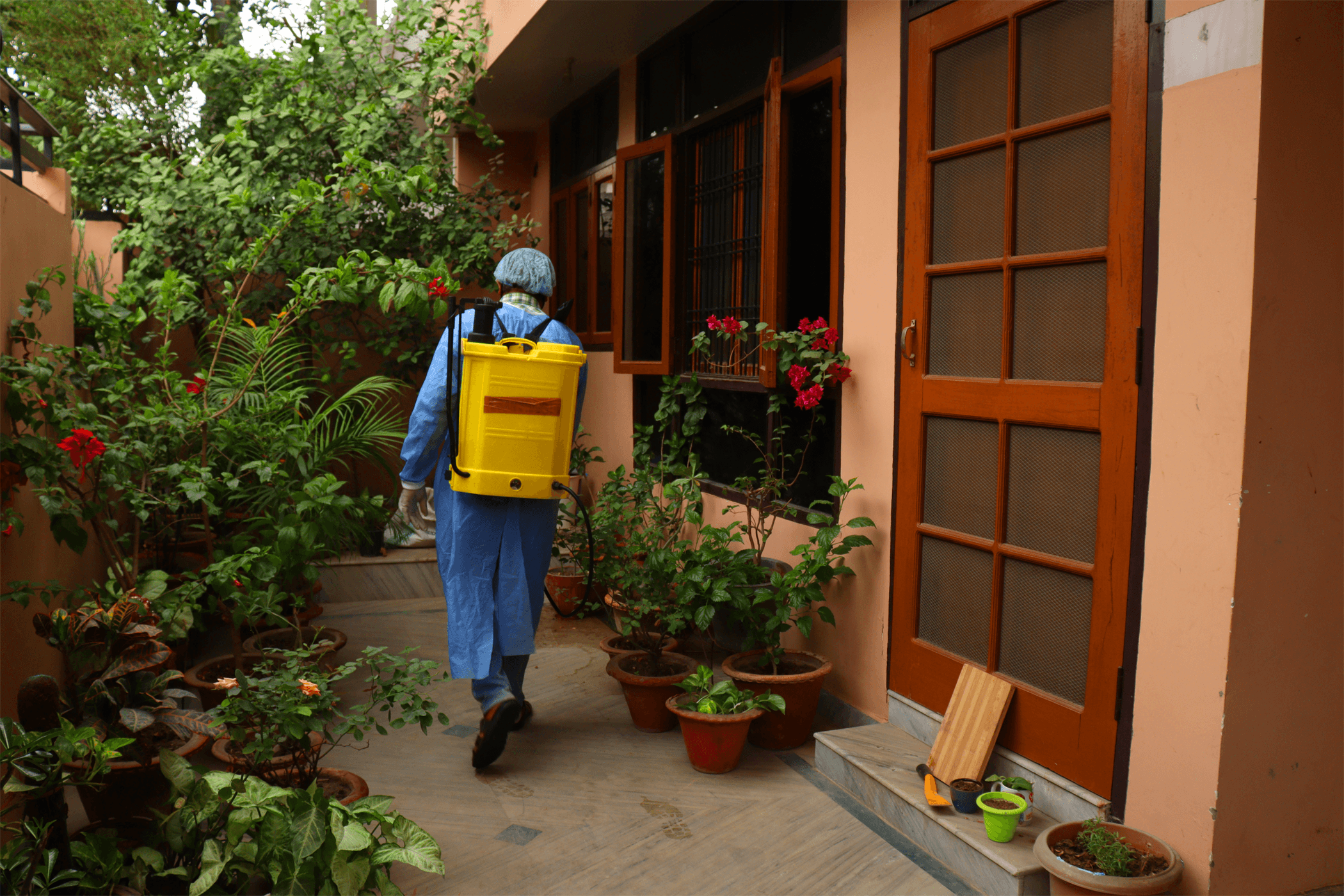 Técnico de U.S. Fumigation revisando el perímetro de una vivienda
